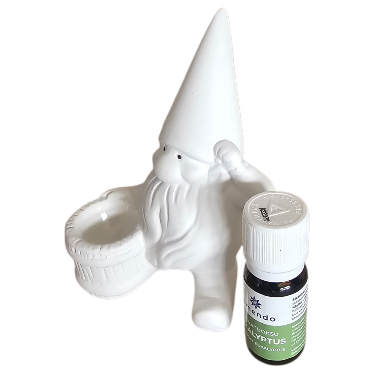 Eine weiße Zwergenfigur aus Keramik, die einen kleinen Korb neben einer Flasche Eukalyptusöl hält.