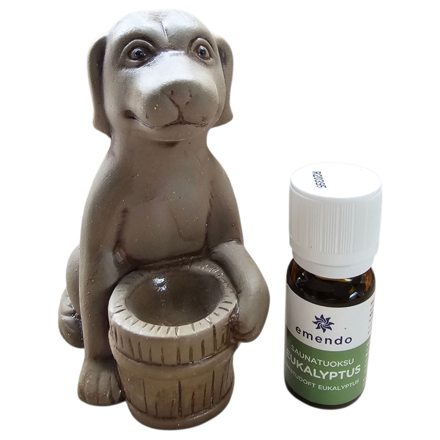 Eine Hundefigur aus Stein hält einen kleinen Eimer neben einer Flasche mit ätherischem Öl.