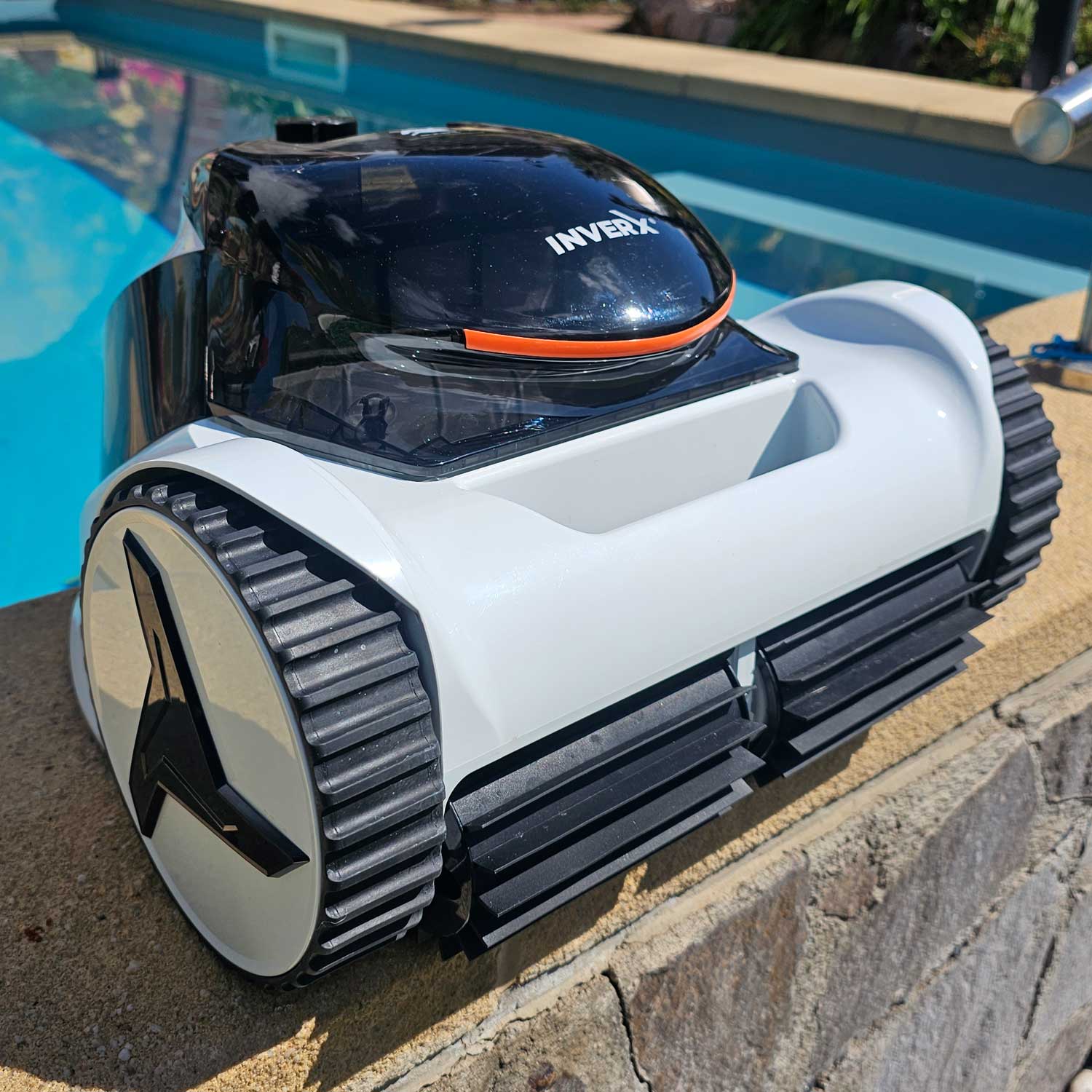 Automatisierter Poolreiniger, der in der Nähe eines Schwimmbadrandes positioniert ist.