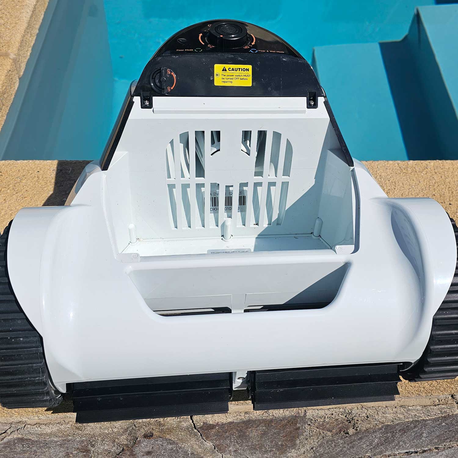 Automatischer Poolreiniger mit weißem Gehäuse und schwarzem Bedienfeld.
